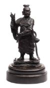 A Chinese bronze standing figure of a deity: wearing traditional costume on a naturalistic base,