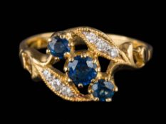 A sapphire and diamond nine-stone cross-over ring: the shank stamped '18K', ring size N.