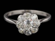 A platinum and diamond circular cluster ring: with central round old,