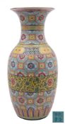A Chinese famille rose baluster vase: painted overall with flowerheads on yellow grounds within