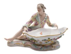 A Meissen figural sweetmeat dish: the seated gallant wearing a pink floral yellow ground jacket,