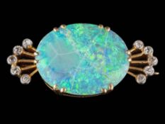 An opal and diamond brooch: the central, oval opal approximately 19mm long x 15mm wide x 3mm deep,