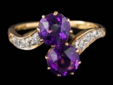 An amethyst and diamond two-stone cross-over ring: set with round amethysts each approximately 6.