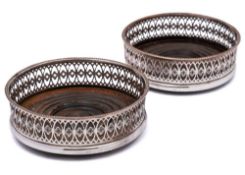 A pair of electro plated wine coasters: of circular outline,