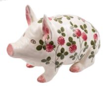 A large Plichta pottery pig money box: modelled in seated position and painted with flowering