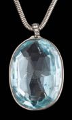 An oval blue topaz single-stone pendant: the faceted oval pale blue topaz approximately 37mm long x