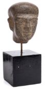 An Egyptian carved hardstone head: mounted on a square plinth base, the head 12cm. high.