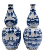 A pair of Chinese blue and white double gourd vases: each painted with figures in continuous lake