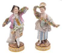 A pair of Meissen figures: of a dancing youth and girl holding elaborate floral garlands,