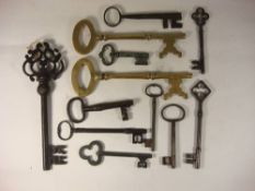 A collection of eleven antique brass, iron and steel keys and a brass key shaped corkscrew.: (12).