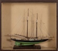 A cased model of a yacht: standing rigged over deck with grates, winch and fittings,
