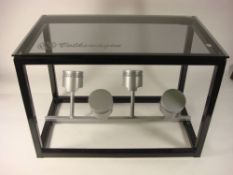 A VW Beetle piston bespoke coffee table: the smoked glass top on a black powder coated frame with a