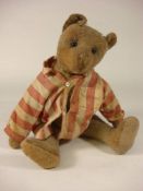 An early 20th century blonde plush Teddy bear: with boot button eyes and remains of stitched mouth
