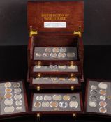 A set of Danbury Mint 'British Coins of World War II' in a collectors cabinet.