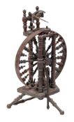A 19th Century fruitwood Castle pattern spinning wheel: with urn-shaped turned spindle spokes and