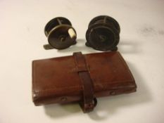 Two brass four bar reels and an Army & Navy leather fly wallet with steel eye flys: (3)