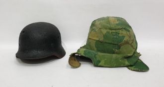 World War II German helmet together with one further helmet in camouflage cover