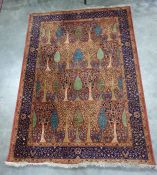 Rust and blue rug featuring stylised pear and other fruiting and flowering trees with a royal blue