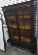 20th century oak display cabinet with two glazed doors enclosing shelves, turned supports and