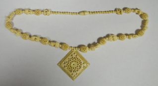 Ivory-coloured bead necklace in the form of miniature elephants alternating with honeycomb beads and
