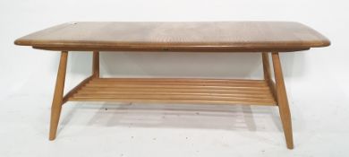 Light elm Ercol oblong coffee table on beech supports and spindle undertier, 105cm x 36cm