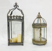 Two garden lanterns for candles, one with glass domed top and cylindical body, one square