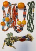 Two bead necklaces, each having large amber-coloured beads amongst others, green hardstone bead