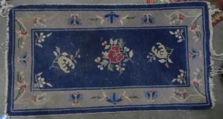 Pair of Chinese blue ground carpets, foliate decoration, 132cm x 75cm (2)