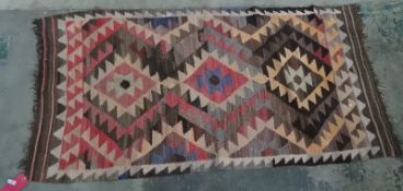 Eastern carpet with three diamond-shaped lozenges, in pinks, blues, greys and peaches, 188cm x 95.