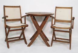 Teak folding garden table and a pair of teak and plastic backed and seated folding chairs, with a