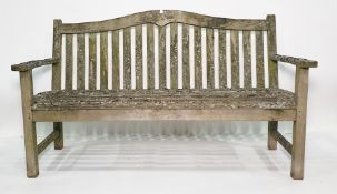 Very weathered garden bench, slat seats and curved back rail