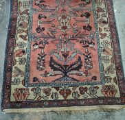 Persian rug, salmon ground decorated in blues, creams and reds, stepped border, 178cm x 104cm