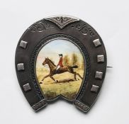 Late Victorian silver brooch in the form of a horseshoe, the centre enamel decorated with horse