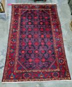 Eastern rug, blue ground with red hooked motifs, canted corners to the central field, wide margin
