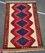 Eastern rug, with five blue ground diamond shaped medallions, in pinks, blues, cream and green,
