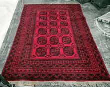 Red ground Persian rug, the central field with 18 elephant's foot guls, on a multi-stepped border,
