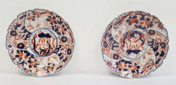 Pair of Japanese Imari circular dishes, each painted with scrolling foliage, bamboo and rockwork,