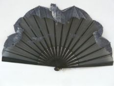 An early 20th century wooden and painted fan, the black organza hand painted with flying bats, the