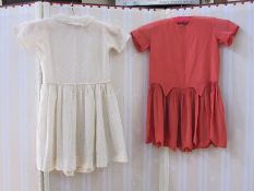 Child's dress in coral-coloured silk and another child's dress with spotted decoration in yellow,