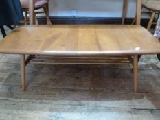Ercol elm coffee table, rounded rectangular with rail under shelf, on turned tapering supports,