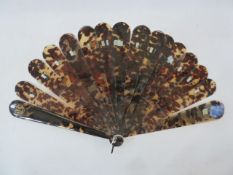 A 19th century tortoiseshell brise fan, plain guards and sticks curved edges, with gilt coloured