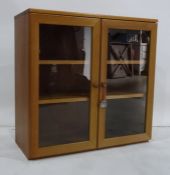 Teak two-door cabinet with two glazed doors enclosing shelves, 75 x 72cm