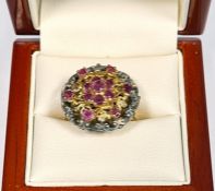 Silver-gilt and ruby cluster ring set seven stones in flowerhead pattern to centre, with surround of