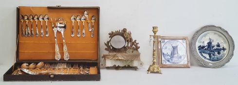 Cased set of flatware, a framed Delft tile, a Delft plate in pewter mount, an ormolu clock mount (