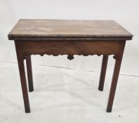 George III mahogany concertina-action card table, the rectangular top with carved border, hinged