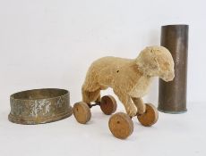 Brass shell case, large brass artillery shell base and a vintage straw-stuffed small toy dog on