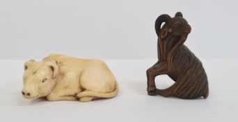 Japanese carved ivory netsuke in the form of a seated bullock, 5cm long and a Japanese carved wood