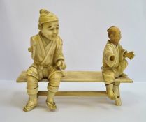 Late 19th century Japanese carved ivory group of two figures seated on bench (each figure with