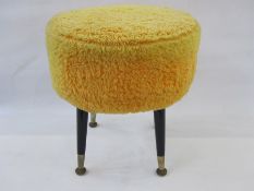 Mid-20th century circular padded stool on ebonised tapering supports with yellow covering, 42cm