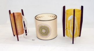 Two mid-20th century table lamps with cylindrical fiberglass coloured shades, on wooden straight